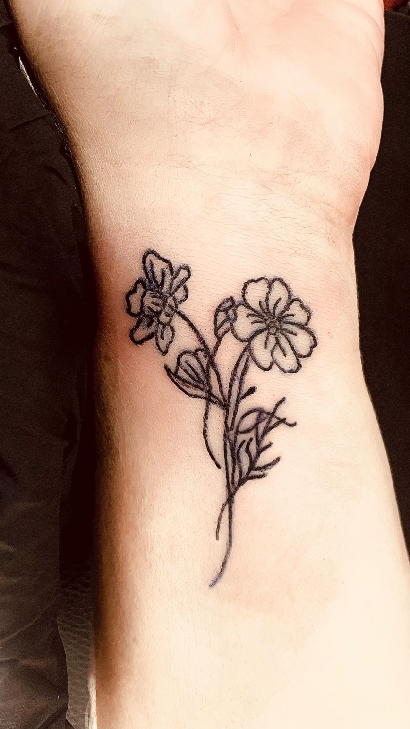 Fine line floral wrist tattoo